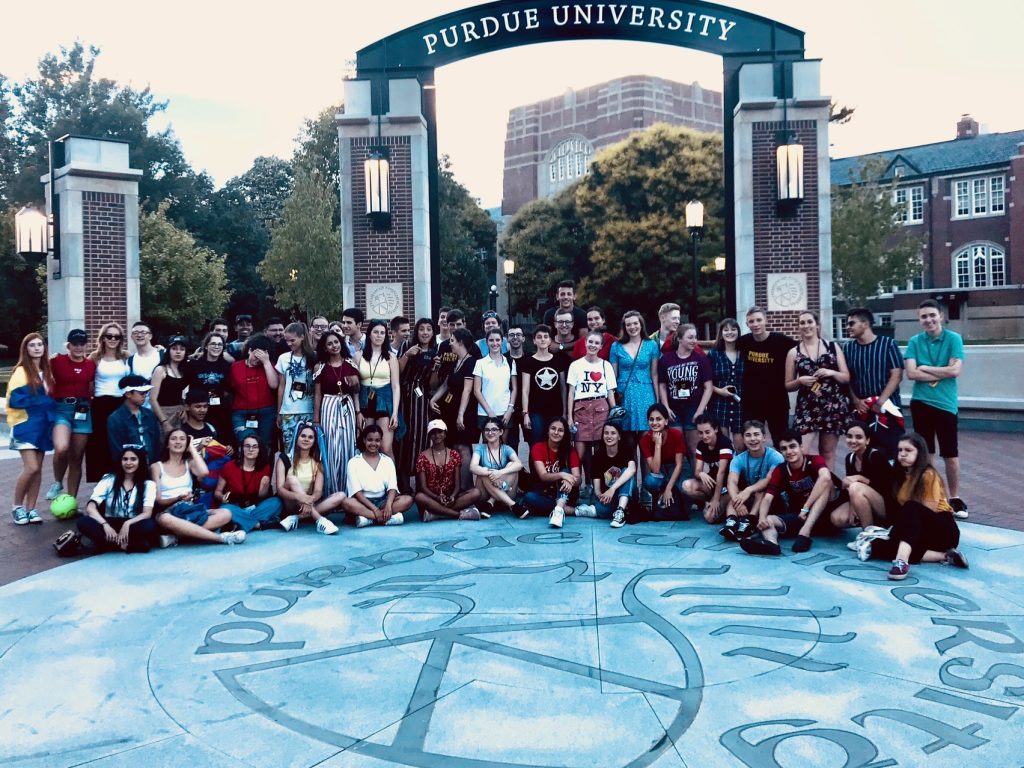 A large group of cohort fellows gathered for a photo outside the Purdue Welcome Arch.